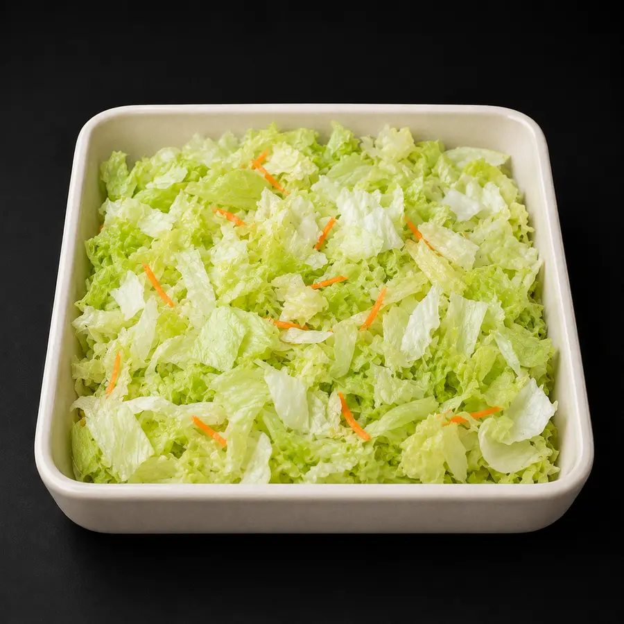 Frisch geschnittener Eisbergsalat mit wenigen Karottenstreifen